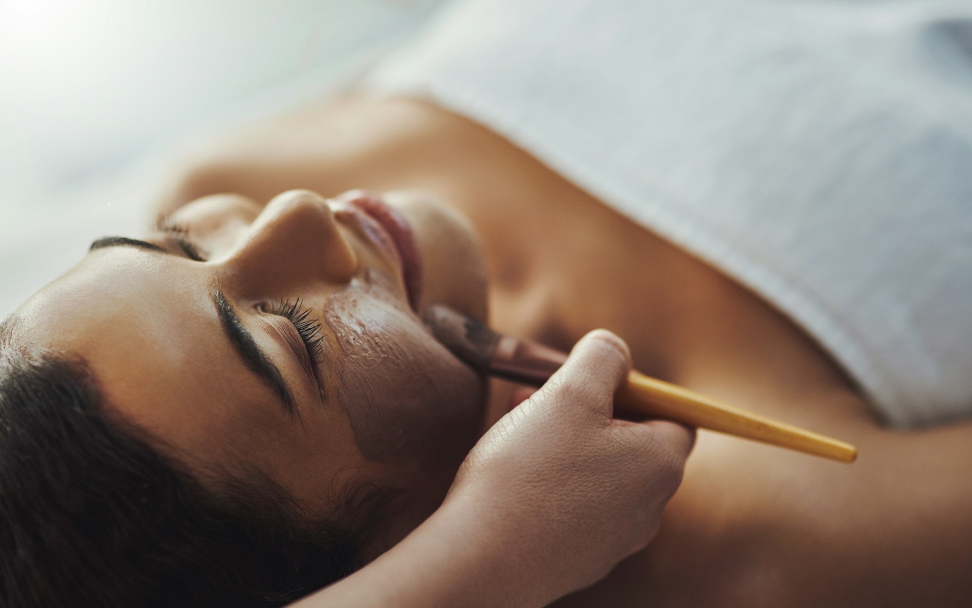 Shot of a young woman getting a facial treatment at a spa